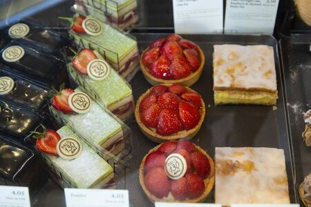 Various sweets and cakes in shop window. Bakery shop in U.K.