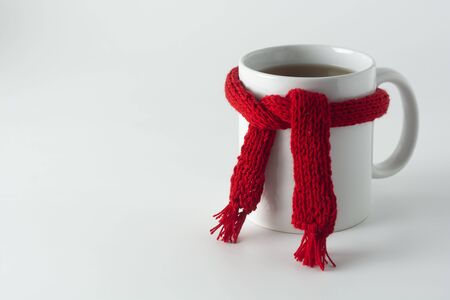 Cup of tea with red knitted scarf. isolated on white Autumn, fall background. Copy space for text.の写真素材