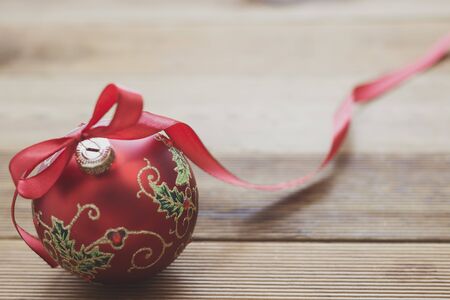 Christmas decoration beautiful red bauble with red ribbon cver wooden background. Copy space.の写真素材