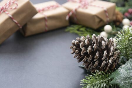 Christmas fir branches, with craft gift boxes. Winter background border over gray board, copy space. Winter greeting card, winter holidays.の写真素材