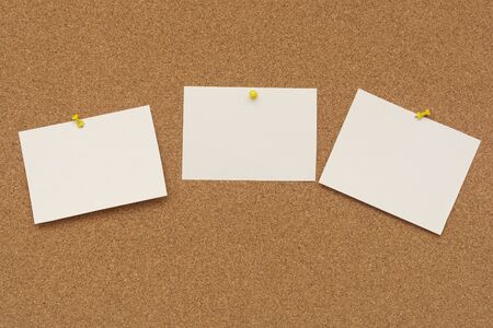 Note paper swith push pins on cork board. Empty paper pages for notes copy space for text.の写真素材