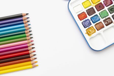 Color pencils and watercolor paints, isolated on a white background with copy space. Office, education concept. Work table, working process.の写真素材