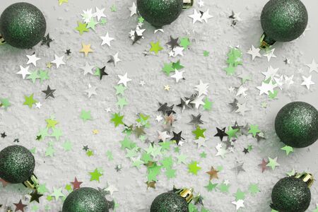 Abstract glittered Christmas background with green baubles over white board. Copy space for text.の写真素材