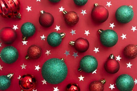 Christmas red background with red and green baubles, glitter with copy space. Winter christmas frame...