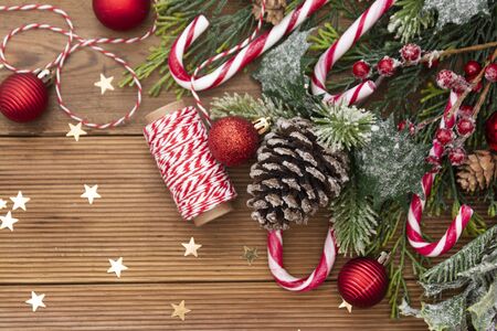 Christmas background with a red and white candie canes, fir branches, winter decoration, star shapes...
