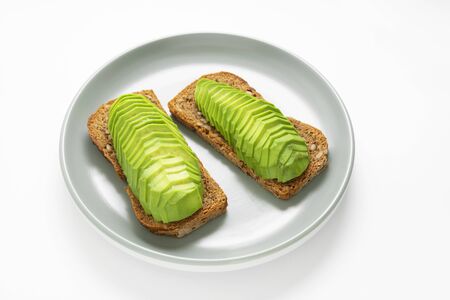 Healthy breakfast toast with avocado slices, white background