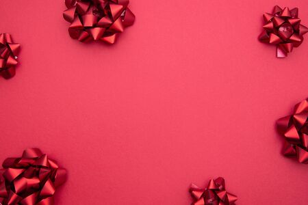 Valentine's Day background. Red ribbon bows over red background, flat lay. Party, birthday, Christmas mock up. Copy space for text.の写真素材