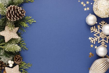 Christmas blue abstract background with silver baubles and fir branches over blue background. Christmas and New Year winter holidays greeting card.の写真素材