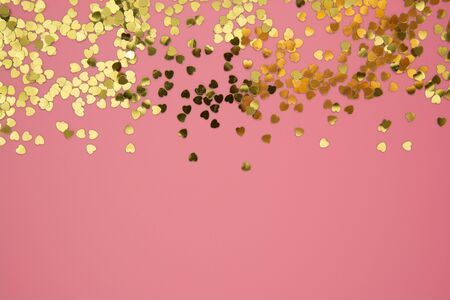 Abstract textured backgraund, golden heart shape glitter over pink background. Valentine's Day, love, birthday, party concept. Flat lay with space for text.の写真素材