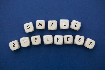 Small business words cubes abstract lettering, blue background, copy space.