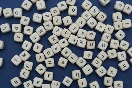 Wooden letter blocks over blue background, flat lay.