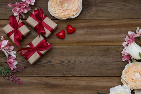 Festive gift boxes and bouquet of flowers on wooden background with copy space. Valentine's dayの写真素材