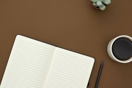Table top of work desk. Open blank white notebook, pencil and cup of coffee on the desk, table top,...
