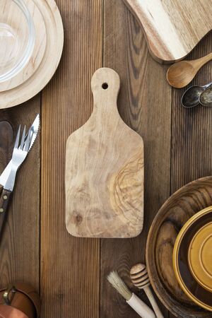 Top view of wooden cutting board on wooden table. Cooking, menu concept. Copy space, menu, recipe or...