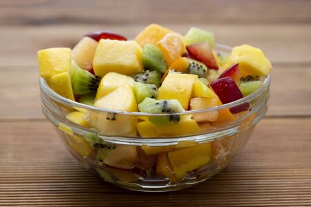 Fresh fruits salad bowl - mango, citrus, kiwi fruit, plum and persimmon. Healthy food.の写真素材