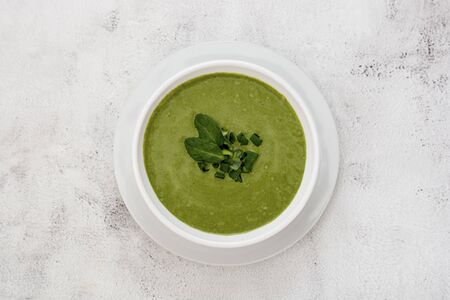 Healthy food. Zucchini creamy soup with spinach on a light background.