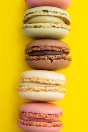 Colorful abstract background with traditional french macaroons cookies, over yellow background with copy space for text.の写真素材