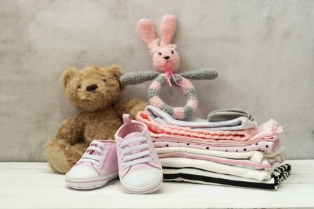Pink baby girl shoes, newborn clothes and soft toys.の写真素材