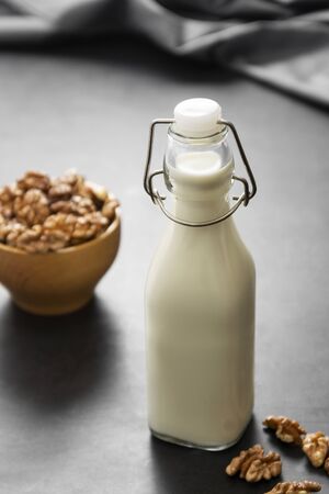 Vegan milk from walnuts on dark board, alternative plant based milkの写真素材