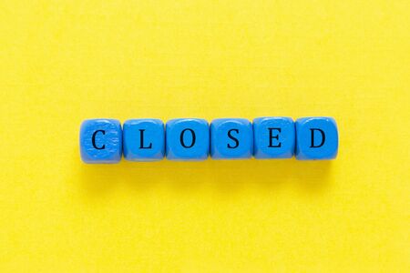 Closed inscription made from blue cubes over yellow background.の写真素材