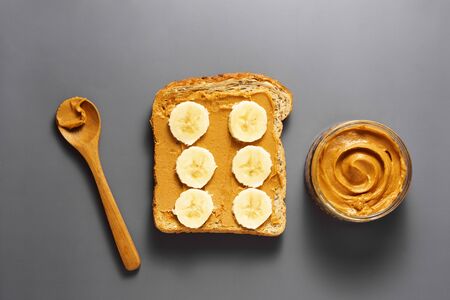 Healthy peanut butter and banana toast over grey background. Top view.の写真素材