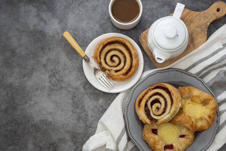 Danish pastry with coffee cup for breakfast. Cinnamon rools buns.