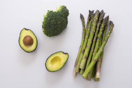 Green vegetables - asparagus, avocado and broccoli. Fresh vegetable mix. Healthy eating concept.
