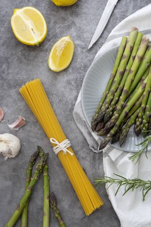 Abstract food background with raw pasta and asparagus on a dark background, cooking healthy foodsの写真素材