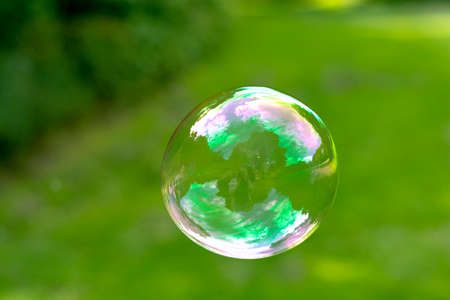 Soap Bubble isolated on green summer background. Kids fun activity.の写真素材