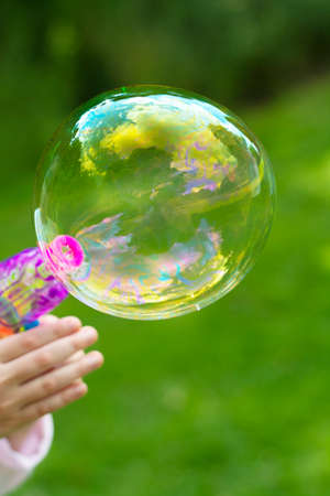 Making soap bubble outdoor. Summer fun activity for kids. Abstract education, play games concept.の写真素材