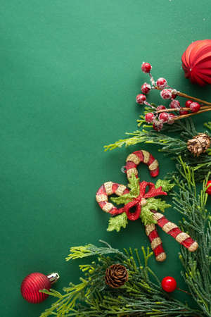 Christmas green background with winter decorations, gift boxes, fir branches, pine cones and red baubles. Copy space, flat lay.の写真素材