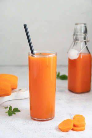 Glass of carrot juice, healthy smoothie drink with black paper straw. Nutrition and diet conceptの写真素材