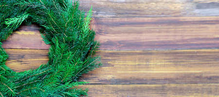 Christmas banner, undecorated evergreen wreath on rustic wooden background with copy space