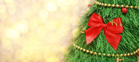 Christmas background banner with Christmas tree, and a big red bow with bokeh lights. Copy spaceの写真素材