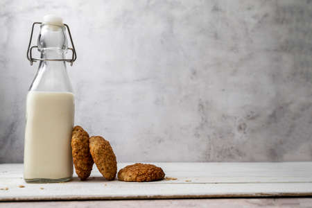 Oat cookies, healthy sweet homemade dessert and a jar with oats over bright backgroundの写真素材