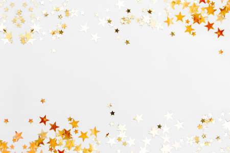 Gold stars glitter on a white background, selective focus, copy space for text