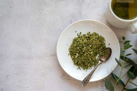 Dry herbal green tea in a plate top view bright backgroundの写真素材