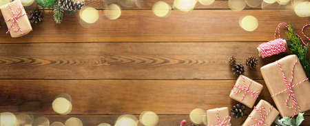 Christmas banner with gift boxes, fir branches and bokeh lights, wooden background. Copy space for textの写真素材
