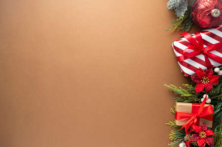 Christmas abstract background. Craft gift boxes with red bow and winter decorations on brown background, top view. Copy space for textの写真素材