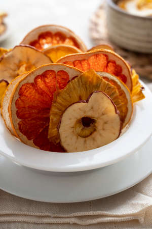 Homemade healthy, organic dried fruit slices. Dried orange, grapefruit, apples, pineapples in a bowl. Healthy snack, dessert.の写真素材