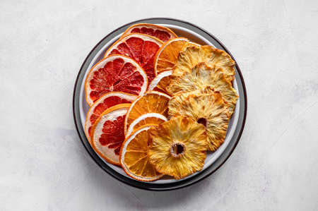 Homemade dried fruit slices. Dried orange, grapefruit, pineapples in a plate. Healthy snack, dessert.の写真素材