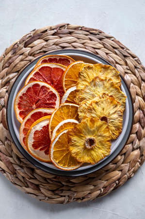 Homemade dried fruit slices. Dried orange, grapefruit, pineapples in a plate. Healthy snack, dessert.の写真素材