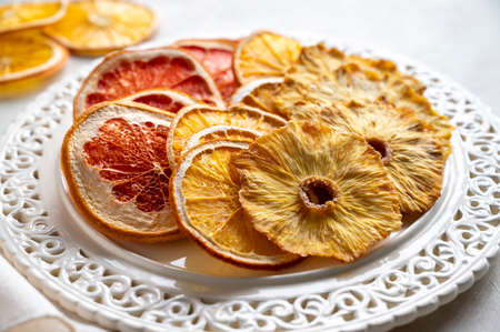 Homemade organic dried fruit slices of orange, grapefruit, pineapple in a plate. Healthy snack, dessertの写真素材