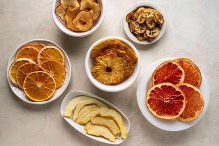 Selection ofdried fruits slices in plates, top view. Dried orange, grapefruit, pineappleの写真素材
