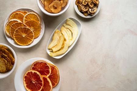 Homemade organic dried fruit slices in plates, top view. Dried orange, grapefruit, pineappleの写真素材