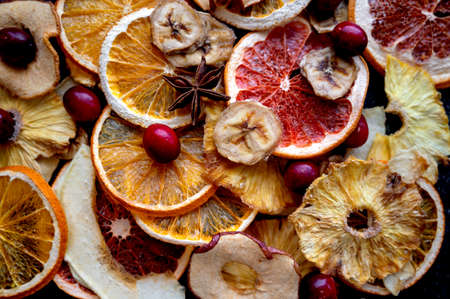Dried fruit slices of orange, apple, banana, mango, grapefruit, pineapple on a dark backgroundsの写真素材
