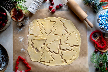 Cooking Christmas cookies. Christmas tree cookie cutter on dough. Step by step recipe. Top view.