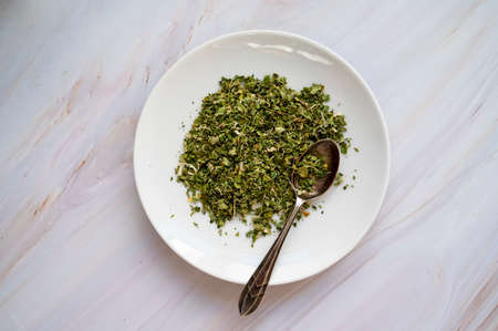 Dry herbal green tea in a plate top view bright backgroundの写真素材