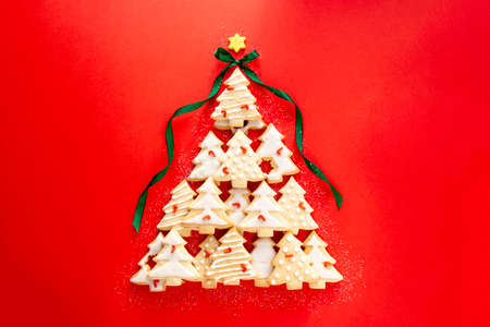 Christmas tree made from christmas tree shaped cookies on red backgroundの写真素材