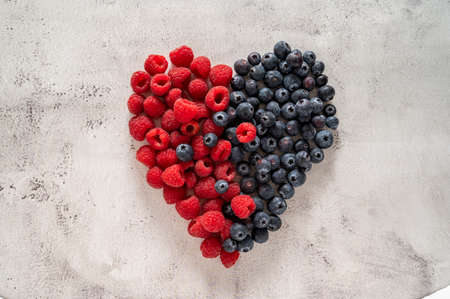 Raspberry and blueberry heart. Healthy food, nutrition and detox concept. Top viewの写真素材